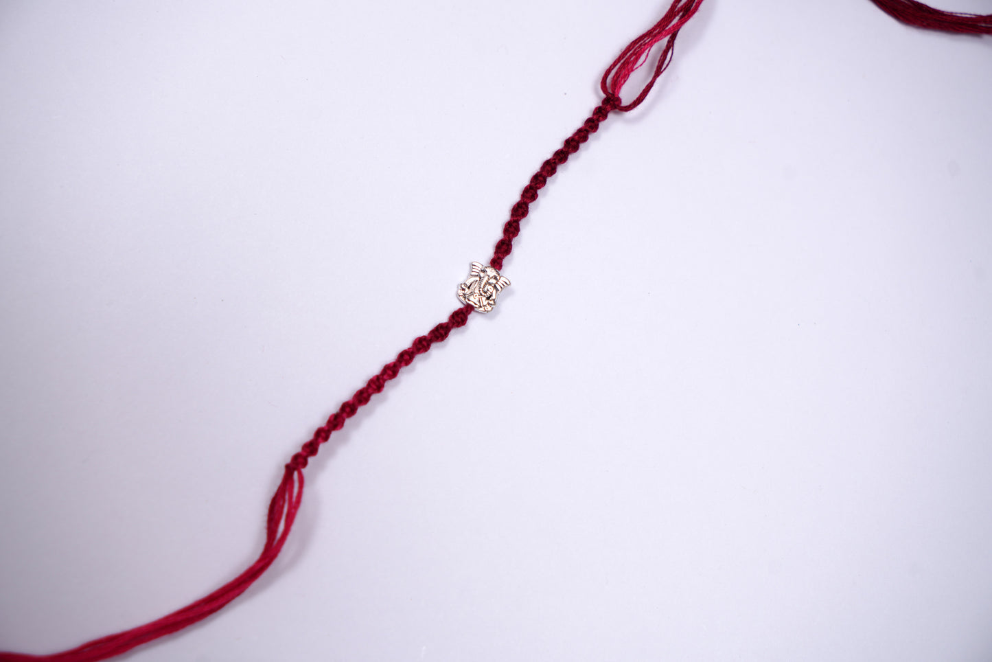 Braided Maroon Rakhi with Silver Lord Ganesha