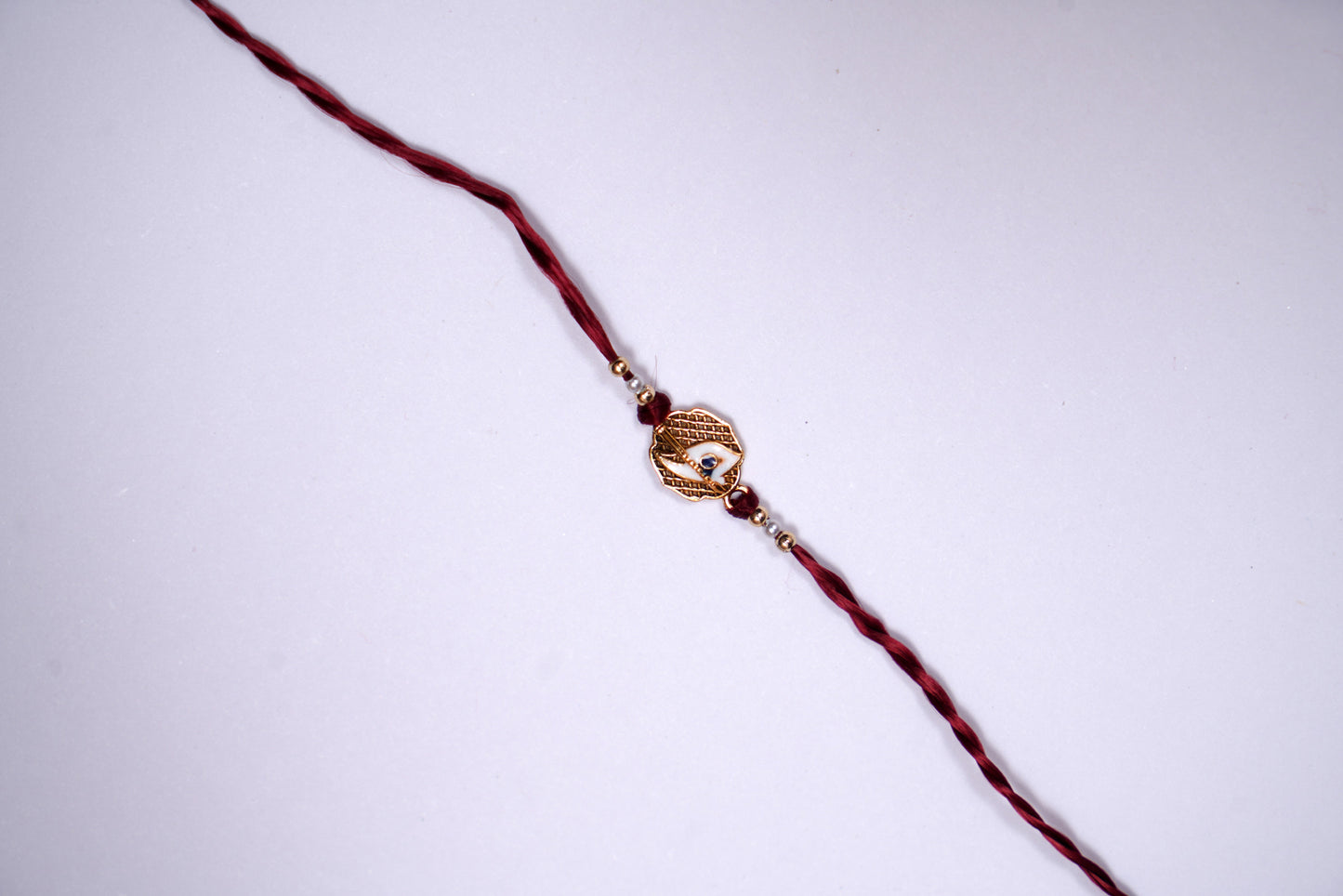Maroon twisted Silk Thread Rakhi with White Mor Pankh Charm