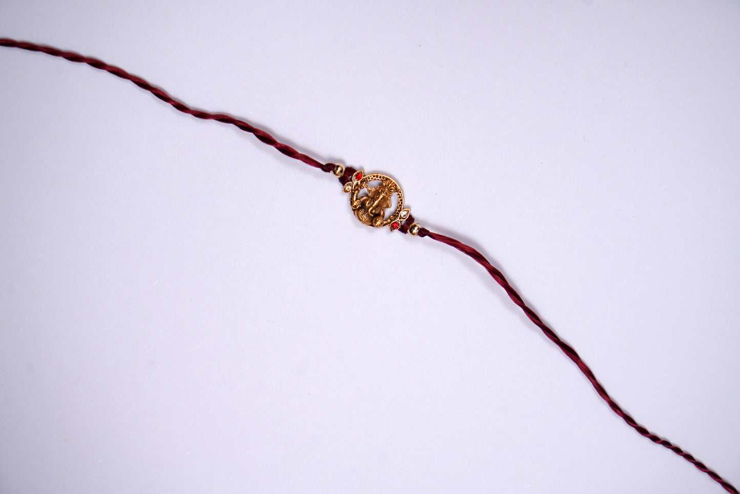 Maroon twisted Silk Thread Rakhi with Lord Ganesha Charm