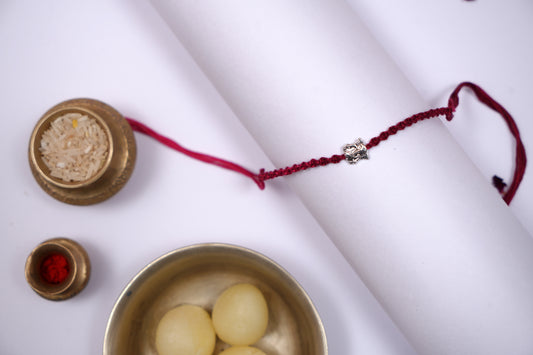 Braided Maroon Rakhi with Silver Lord Ganesha