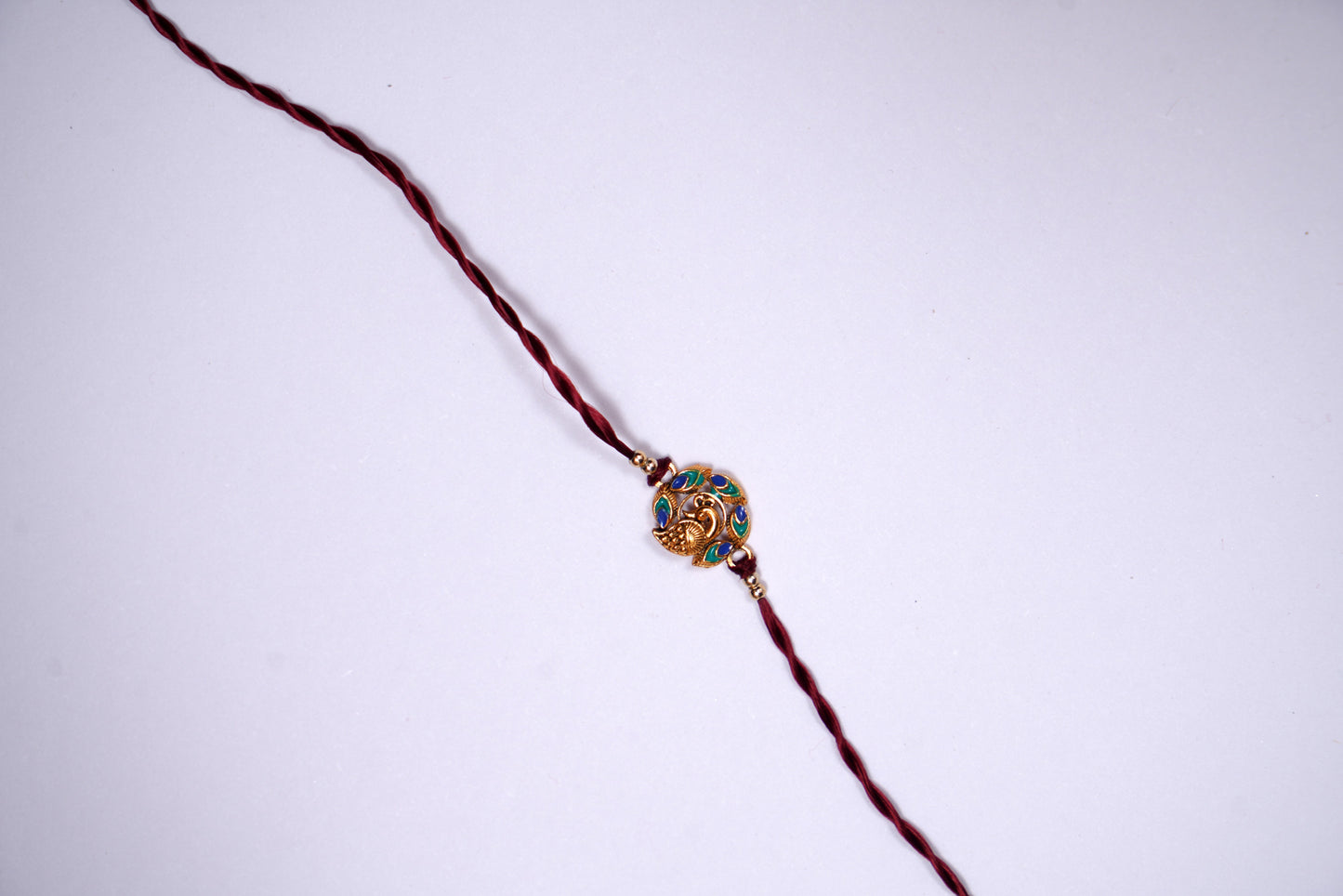 Maroon twisted Silk Thread Rakhi with Mor Charm