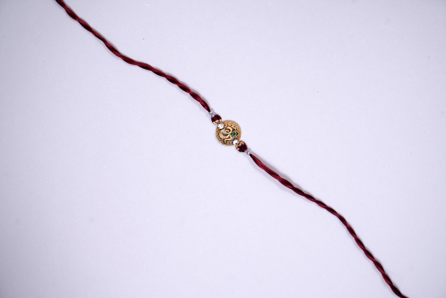Maroon twisted Silk Thread Rakhi with Om Charm
