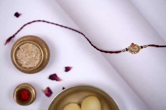 Maroon twisted Silk Thread Rakhi with Peacock Charm