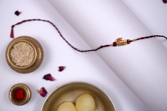 Maroon twisted Silk Thread Rakhi with Radha Krishna Charm